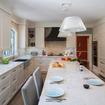 Enclosed kitchen - traditional l-shaped enclosed kitchen idea in Philadelphia with stone tile backsplash, recessed-panel cabinets, paneled appliances and a farmhouse sink