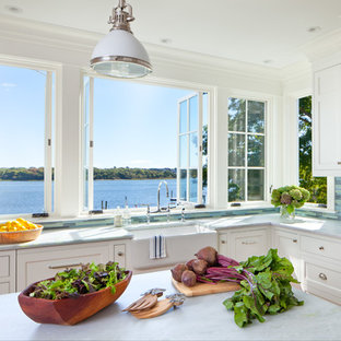 Ejemplo de cocina en L, costera, con fregadero sobremueble, armarios estilo shaker, puertas de armario blancas, salpicadero multicolor, salpicadero de azulejos en listel, electrodomésticos de acero inoxidable y una isla