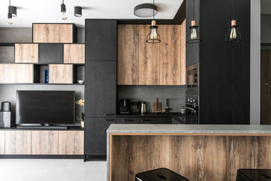 リヨンにある中くらいなコンテンポラリースタイルのおしゃれなキッチン (フラットパネル扉のキャビネット、黒いキャビネット、グレーのキッチンパネル、パネルと同色の調理設備、グレーの床) の写真