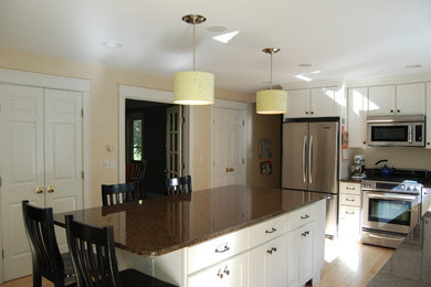 Пример оригинального дизайна: кухня среднего размера с обеденным столом, островом и гранитной столешницей