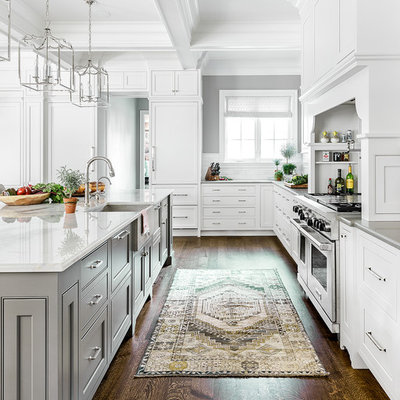 Inspiration for a large transitional brown floor and dark wood floor kitchen remodel in Chicago with a farmhouse sink, beaded inset cabinets, white cabinets, white backsplash, ceramic backsplash, stainless steel appliances and an island