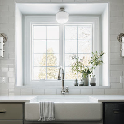 Example of a mid-sized transitional dark wood floor eat-in kitchen design in Chicago with a farmhouse sink, shaker cabinets, gray cabinets, quartz countertops, white backsplash, ceramic backsplash, paneled appliances, an island and white countertops