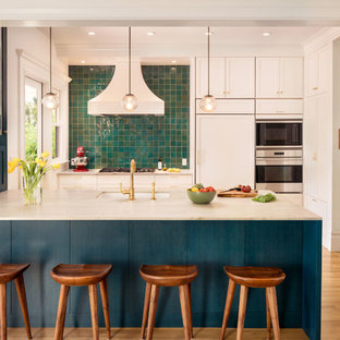Immagine di una cucina parallela design con lavello sottopiano, ante in stile shaker, ante bianche, paraspruzzi blu, elettrodomestici da incasso, pavimento in legno massello medio, pavimento marrone e top beige
