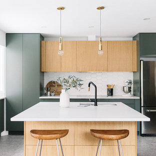 Photo of a scandi kitchen in Edmonton with a submerged sink, flat-panel cabinets, green cabinets, white splashback, stainless steel appliances, concrete flooring, an island, grey floors and white worktops.