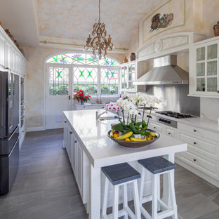 Traditional galley kitchen in Sydney with raised-panel cabinets, white cabinets, white splashback, stainless steel appliances, with island, grey floor and white benchtop.