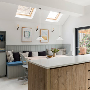 Klassische Wohnküche mit flächenbündigen Schrankfronten, hellen Holzschränken und Kücheninsel in London