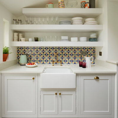 Transitional gray floor kitchen photo in London with a farmhouse sink, shaker cabinets, white cabinets, multicolored backsplash and white countertops