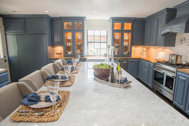 Inspiration for a large timeless u-shaped dark wood floor and black floor open concept kitchen remodel in Houston with a farmhouse sink, raised-panel cabinets, blue cabinets, wood countertops, white backsplash, ceramic backsplash, stainless steel appliances and an island