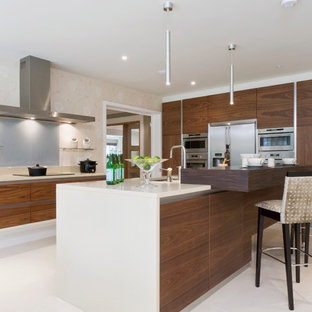 Inspiration for a medium sized contemporary kitchen in Buckinghamshire with flat-panel cabinets, grey splashback, glass sheet splashback, stainless steel appliances, an island, white floors, white worktops, a submerged sink and dark wood cabinets.