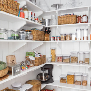 Medium sized country kitchen pantry in Boston with a belfast sink, open cabinets, white cabinets, marble worktops, stainless steel appliances, light hardwood flooring and an island.