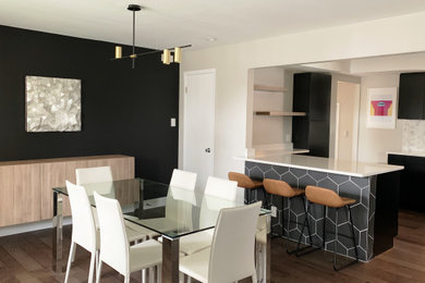 Mid-sized minimalist galley medium tone wood floor and vaulted ceiling eat-in kitchen photo in Denver with an undermount sink, flat-panel cabinets, black cabinets, quartzite countertops, white backsplash, marble backsplash, stainless steel appliances, a peninsula and white countertops