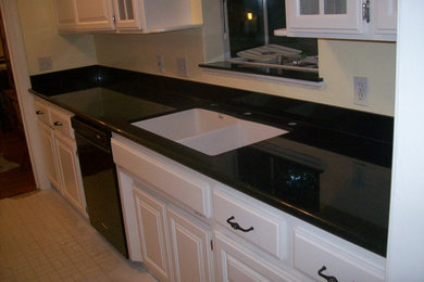 Imagen de cocina comedor lineal de tamaño medio con fregadero de doble seno, puertas de armario blancas, encimera de granito y suelo de linóleo