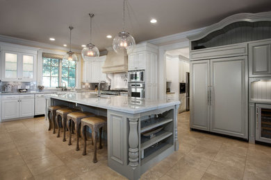 Inspiration for a large timeless l-shaped travertine floor and brown floor enclosed kitchen remodel in Salt Lake City with a farmhouse sink, raised-panel cabinets, white cabinets, marble countertops, gray backsplash, stone slab backsplash, paneled appliances, an island and gray countertops