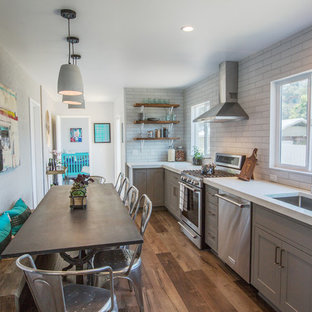 Design ideas for a small modern l-shaped eat-in kitchen in Los Angeles with an undermount sink, shaker cabinets, grey cabinets, concrete benchtops, white splashback, ceramic splashback, stainless steel appliances, laminate floors, no island and brown floor.