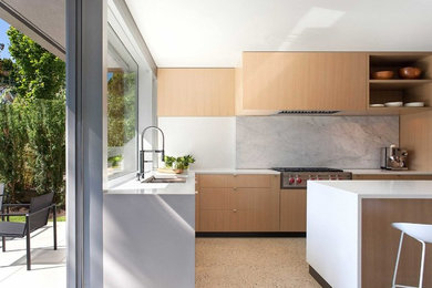 Eat-in kitchen - large modern l-shaped concrete floor eat-in kitchen idea in Vancouver with an undermount sink, flat-panel cabinets, light wood cabinets, quartz countertops, gray backsplash, stone slab backsplash, stainless steel appliances and an island