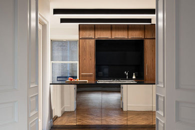 ニューヨークにある高級な中くらいなモダンスタイルのおしゃれなキッチン (アンダーカウンターシンク、フラットパネル扉のキャビネット、ステンレスキャビネット、クオーツストーンカウンター、黒いキッチンパネル、石スラブのキッチンパネル、シルバーの調理設備、大理石の床、白い床、黒いキッチンカウンター) の写真