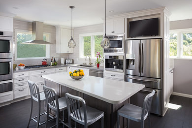 Large trendy l-shaped porcelain tile eat-in kitchen photo in San Francisco with an undermount sink, shaker cabinets, gray cabinets, solid surface countertops, gray backsplash, ceramic backsplash, stainless steel appliances and an island