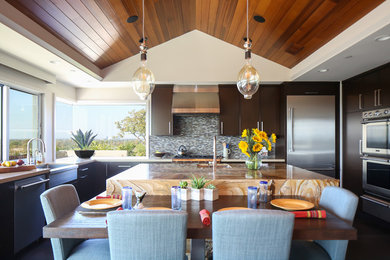 Eat-in kitchen - large contemporary u-shaped porcelain tile eat-in kitchen idea in Orange County with an undermount sink, flat-panel cabinets, dark wood cabinets, quartz countertops, multicolored backsplash, glass tile backsplash, stainless steel appliances and an island
