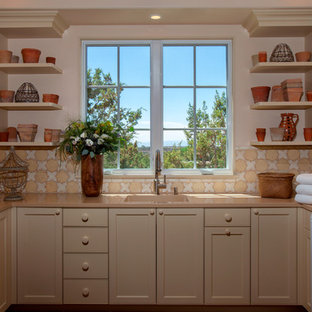 Southwestern enclosed kitchen photos - Example of a southwest enclosed kitchen design in Albuquerque with a drop-in sink, flat-panel cabinets, white cabinets, marble countertops, yellow backsplash, mosaic tile backsplash, stainless steel appliances and no island
