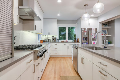 Kitchen - contemporary l-shaped light wood floor and beige floor kitchen idea in Grand Rapids with an undermount sink, flat-panel cabinets, white cabinets, gray backsplash and stainless steel appliances