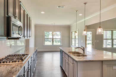 Mid-sized transitional l-shaped dark wood floor and brown floor open concept kitchen photo in Other with an undermount sink, recessed-panel cabinets, dark wood cabinets, granite countertops, white backsplash, subway tile backsplash, stainless steel appliances and an island