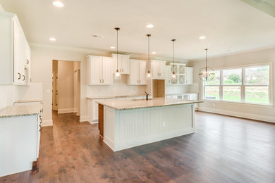 Example of a large transitional l-shaped dark wood floor and brown floor open concept kitchen design in Other with an undermount sink, recessed-panel cabinets, white cabinets, granite countertops, white backsplash, subway tile backsplash, stainless steel appliances and an island
