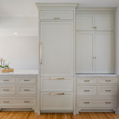 Eat-in kitchen - mid-sized traditional u-shaped light wood floor and brown floor eat-in kitchen idea in Minneapolis with a farmhouse sink, flat-panel cabinets, gray cabinets, marble countertops, gray backsplash, marble backsplash, paneled appliances, a peninsula and gray countertops