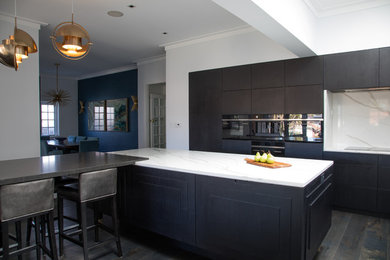 シドニーにあるラグジュアリーな巨大なコンテンポラリースタイルのおしゃれなキッチン (ダブルシンク、レイズドパネル扉のキャビネット、黒いキャビネット、クオーツストーンカウンター、白いキッチンパネル、石スラブのキッチンパネル、黒い調理設備、濃色無垢フローリング、黒い床、白いキッチンカウンター) の写真
