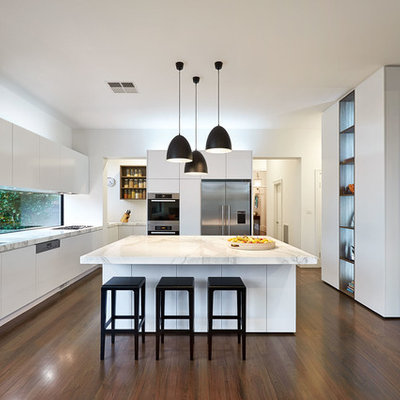 Kitchen - contemporary u-shaped dark wood floor kitchen idea in Melbourne with a double-bowl sink, flat-panel cabinets, white cabinets, stainless steel appliances and an island