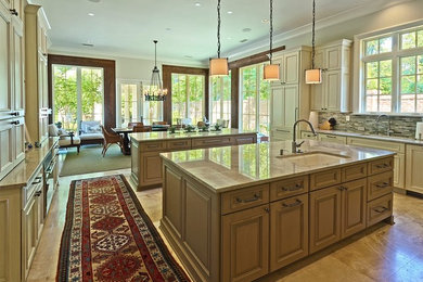 オマハにある高級な巨大なトランジショナルスタイルのおしゃれなマルチアイランドキッチン (落し込みパネル扉のキャビネット、パネルと同色の調理設備) の写真