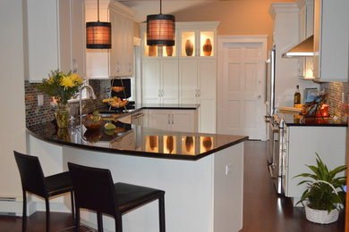 Ejemplo de cocina actual con puertas de armario blancas, encimera de granito, salpicadero gris, electrodomésticos de acero inoxidable y suelo de madera oscura
