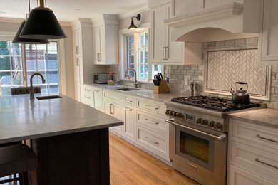 Example of a mid-sized transitional medium tone wood floor and beige floor eat-in kitchen design in Providence with an undermount sink, shaker cabinets, white cabinets, quartzite countertops, gray backsplash, marble backsplash, stainless steel appliances, an island and gray countertops