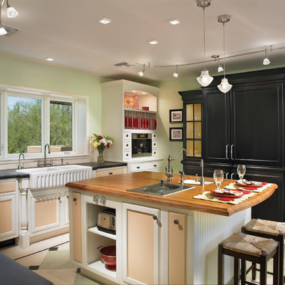Eat-in kitchen - huge traditional u-shaped linoleum floor and beige floor eat-in kitchen idea in Phoenix with recessed-panel cabinets, a farmhouse sink, wood countertops, white backsplash and an island