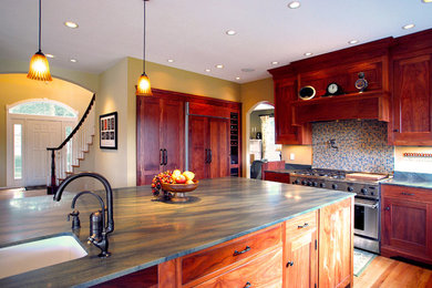 Example of a large classic l-shaped light wood floor eat-in kitchen design in Portland with an undermount sink, granite countertops, stainless steel appliances, shaker cabinets, medium tone wood cabinets, multicolored backsplash, mosaic tile backsplash and an island