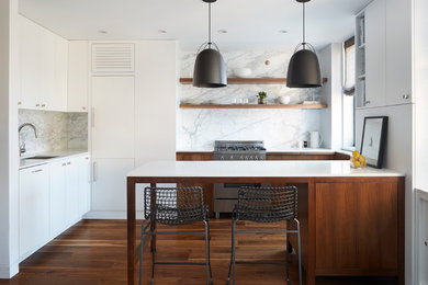 Example of a trendy u-shaped medium tone wood floor open concept kitchen design in New York with an undermount sink, flat-panel cabinets, medium tone wood cabinets, white backsplash and a peninsula