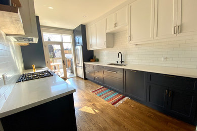 Mid-sized trendy galley medium tone wood floor and brown floor eat-in kitchen photo in Toronto with an undermount sink, recessed-panel cabinets, blue cabinets, quartz countertops, white backsplash, subway tile backsplash, stainless steel appliances, no island and white countertops