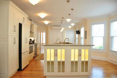 Diseño de cocina tradicional grande abierta con puertas de armario blancas, encimera de granito, electrodomésticos blancos, suelo de madera en tonos medios y una isla