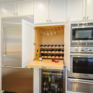 Large farmhouse kitchen in San Francisco with white cabinets, stainless steel appliances, recessed-panel cabinets, medium hardwood flooring and brown floors.
