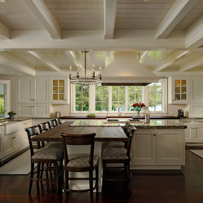 Inspiration for a large timeless u-shaped dark wood floor eat-in kitchen remodel in Baltimore with white cabinets, granite countertops, white backsplash, subway tile backsplash, an island, paneled appliances, a farmhouse sink and raised-panel cabinets