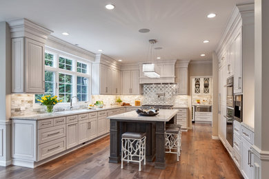 Example of a mid-sized trendy u-shaped medium tone wood floor enclosed kitchen design in Seattle with an undermount sink, shaker cabinets, beige cabinets, granite countertops, multicolored backsplash, mosaic tile backsplash, stainless steel appliances, an island and gray countertops