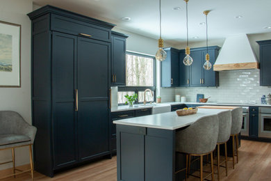 Example of a l-shaped brown floor kitchen design in Other with a farmhouse sink, flat-panel cabinets, white backsplash, an island, white countertops and blue cabinets