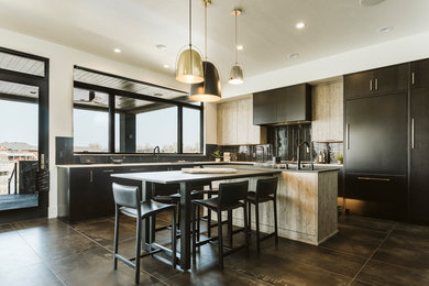 Kitchen - contemporary l-shaped gray floor kitchen idea in Other with flat-panel cabinets, black cabinets, black backsplash, matchstick tile backsplash, paneled appliances and an island