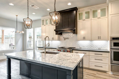 Example of a large kitchen design in Houston with shaker cabinets, white cabinets, stainless steel appliances and an island