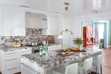 Example of a mid-sized classic single-wall light wood floor eat-in kitchen design in New York with white cabinets, marble countertops, white backsplash, marble backsplash, stainless steel appliances, an island and white countertops