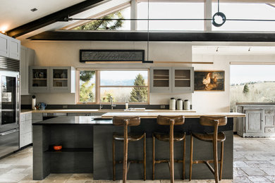 Example of a mid-sized eclectic l-shaped concrete floor and beige floor eat-in kitchen design in Other with an undermount sink, shaker cabinets, gray cabinets, granite countertops, stainless steel appliances and an island