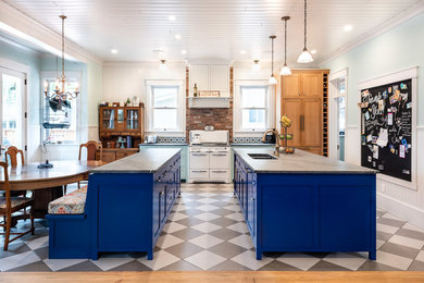 Foto di una grande cucina eclettica con lavello a doppia vasca, ante in stile shaker, ante blu, paraspruzzi multicolore, paraspruzzi in mattoni, pavimento in gres porcellanato, 2 o più isole, pavimento multicolore e top grigio