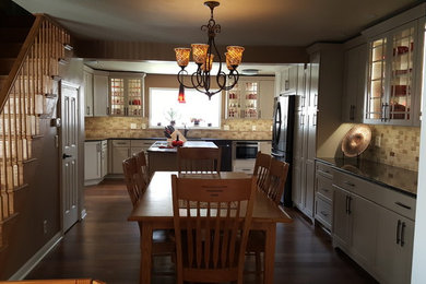他の地域にある高級な広いエクレクティックスタイルのおしゃれなキッチン (シェーカースタイル扉のキャビネット、クオーツストーンカウンター、竹フローリング、茶色い床) の写真