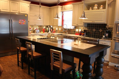 Example of a mid-sized cottage l-shaped ceramic tile eat-in kitchen design in Indianapolis with a farmhouse sink, raised-panel cabinets, white cabinets, granite countertops, multicolored backsplash, stone tile backsplash, stainless steel appliances and an island