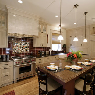 Eclectic kitchen designs - Inspiration for an eclectic kitchen remodel in Minneapolis with paneled appliances, a farmhouse sink, beige cabinets, quartz countertops, red backsplash and ceramic backsplash