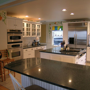 Photo of a large country u-shaped eat-in kitchen in Portland Maine with an undermount sink, louvered cabinets, white cabinets, white splashback, porcelain splashback, stainless steel appliances, ceramic floors, with island and granite benchtops.